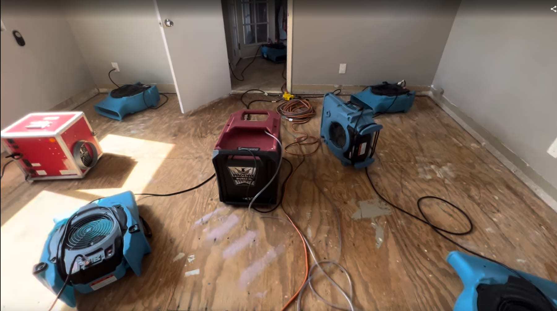 Bedroom with the flooring removed and the subfloor drying under air movers